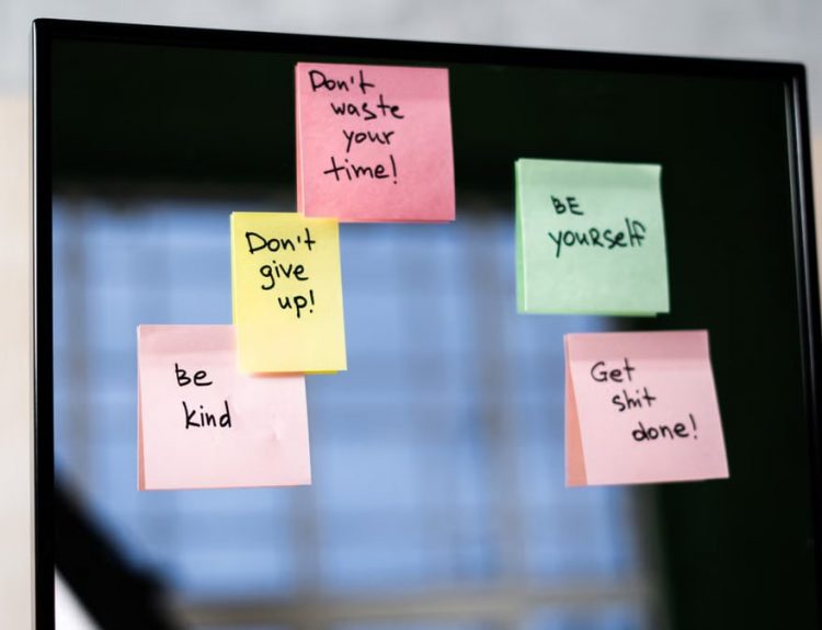 Colorful sticky notes on a mirror provide daily motivational messages and positivity reminders.
